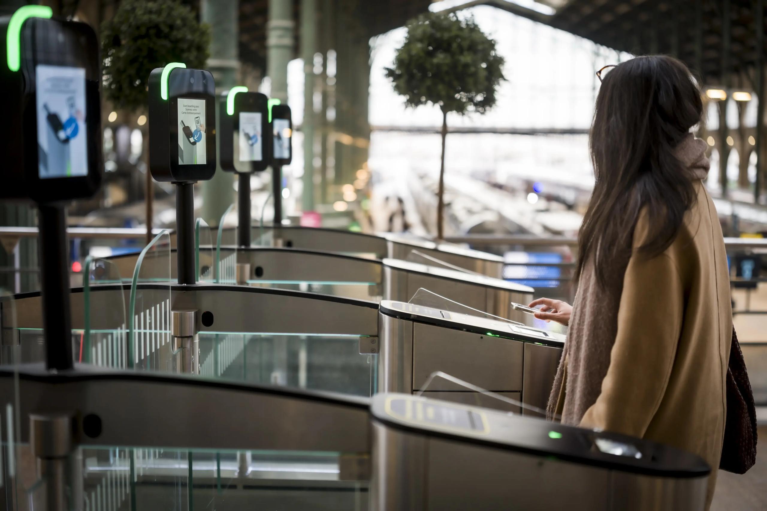 User presenting a credential at automated access control gates in a transport facility.