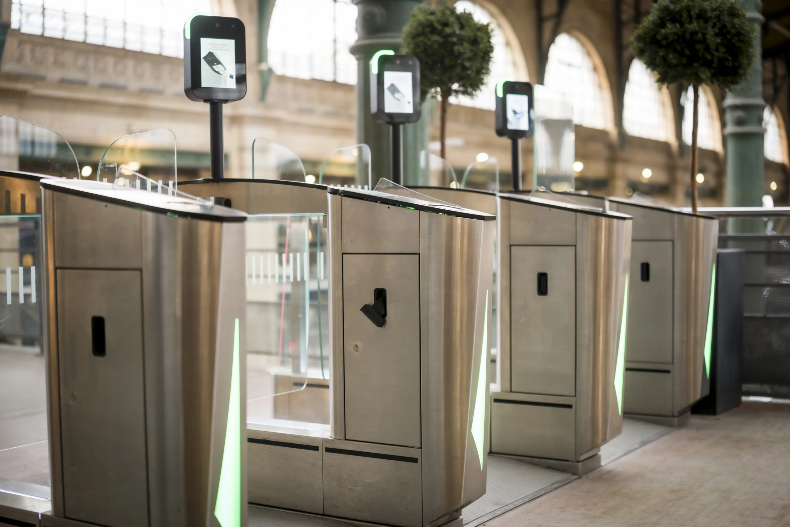 Portillons automatiques de contrôle d’accès avec lecteurs intégrés dans un environnement de transport.